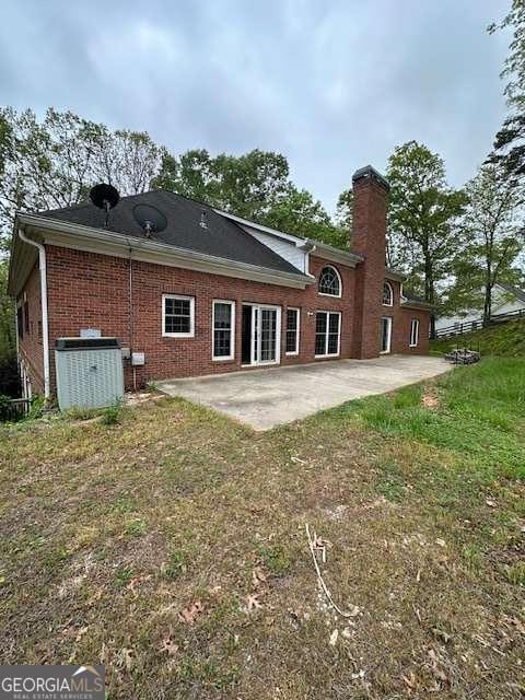 8010 Scudder Way, Ball Ground, GA 30107 - back of house featuring a patio, brick siding, and a chimney