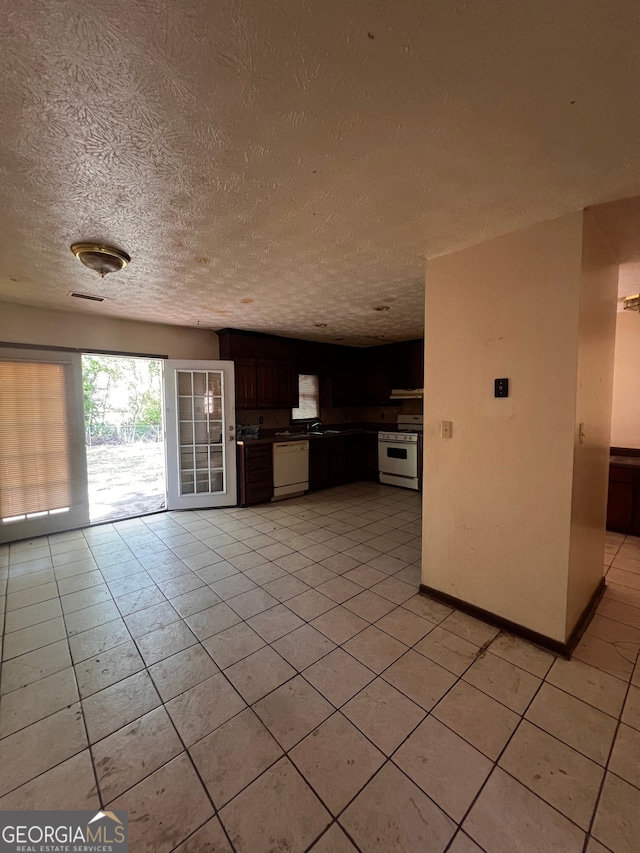 unfurnished living room with visible vents, light tile patterned floors, and a textured ceiling