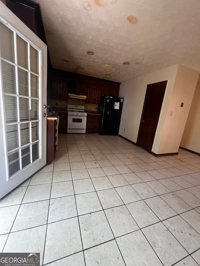 kitchen featuring white gas range, light tile patterned flooring, black fridge with ice dispenser, and a textured ceiling