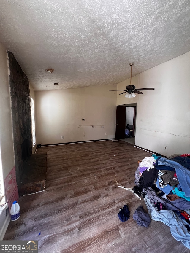 unfurnished living room with lofted ceiling, a textured ceiling, wood finished floors, and ceiling fan