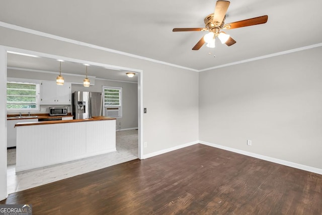 98 Orchard Cir, Commerce, GA 30529 - unfurnished living room with wood finished floors, plenty of natural light, crown molding, and a ceiling fan