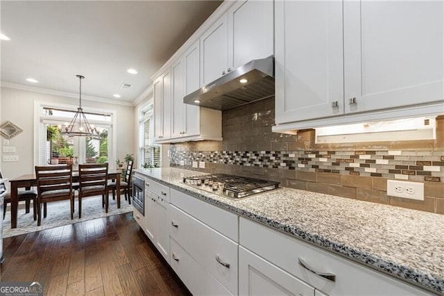 860 Hargrove Point Way, Alpharetta, GA 30004 - kitchen with stainless steel gas cooktop, under cabinet range hood, dark wood-type flooring, ornamental molding, and white cabinets