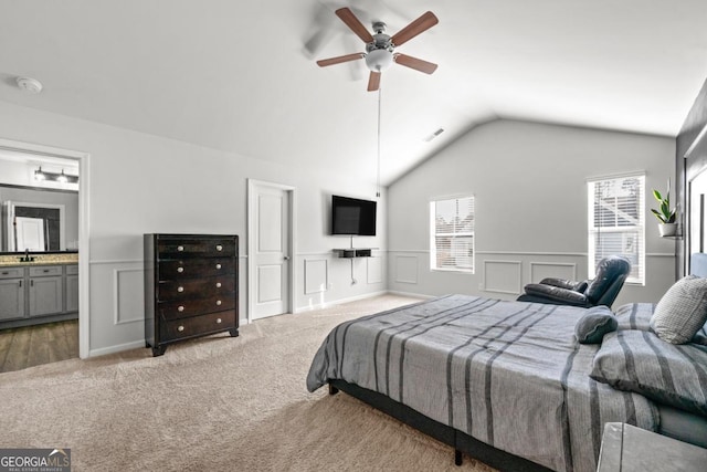 bedroom featuring visible vents, a decorative wall, carpet, and a sink
