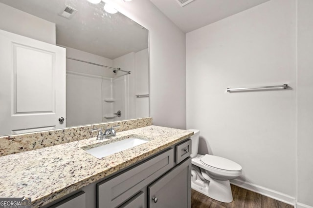full bathroom with vanity, toilet, visible vents, walk in shower, and wood finished floors