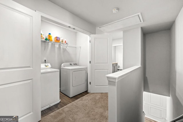 laundry room with wood finished floors, attic access, separate washer and dryer, and laundry area