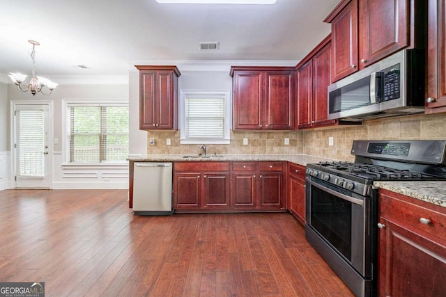 535 Pierpoint Dr, Atlanta, GA 30331 - kitchen with visible vents, a sink, a chandelier, reddish brown cabinets, and appliances with stainless steel finishes
