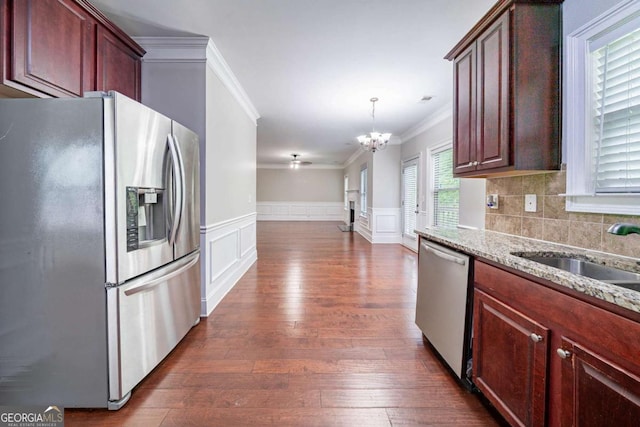 535 Pierpoint Dr, Atlanta, GA 30331 - kitchen featuring a wainscoted wall, ornamental molding, light stone counters, an inviting chandelier, and appliances with stainless steel finishes