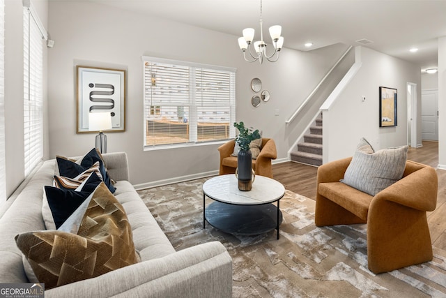living area featuring a chandelier, recessed lighting, baseboards, wood finished floors, and stairway