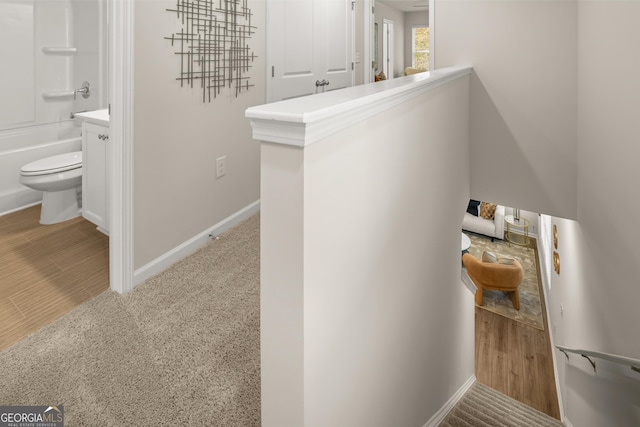 interior space with toilet, baseboards, and washtub / shower combination