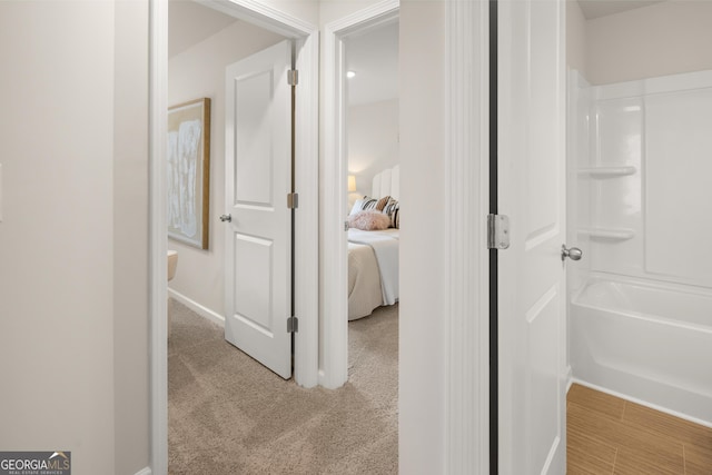 hallway featuring baseboards and carpet