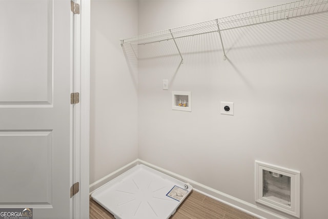 clothes washing area featuring wood finished floors, electric dryer hookup, baseboards, and hookup for a washing machine