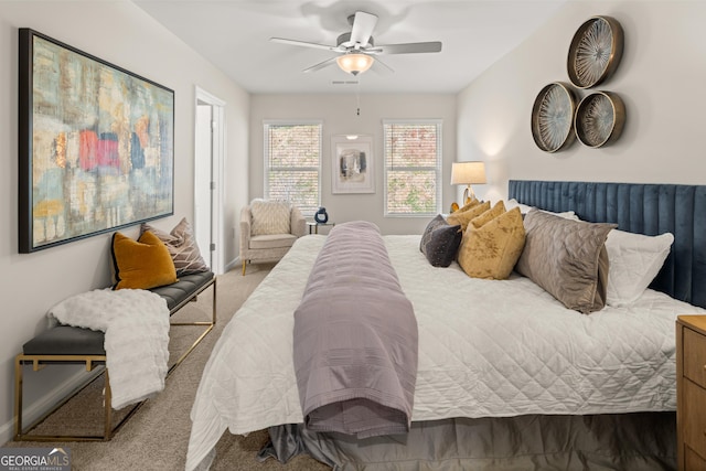 carpeted bedroom with a ceiling fan and visible vents