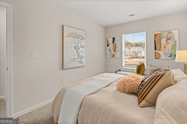 carpeted bedroom with visible vents and baseboards