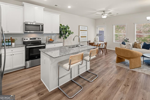 kitchen featuring ceiling fan, visible vents, appliances with stainless steel finishes, a sink, and white cabinets