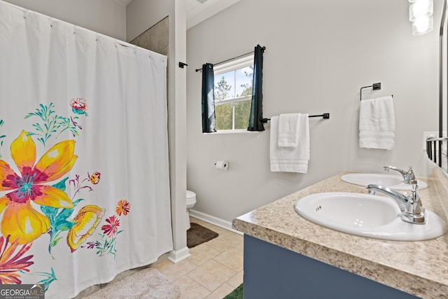 bathroom with toilet, baseboards, tile patterned flooring, and a sink