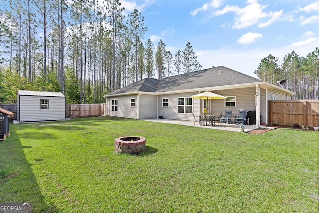 back of property with a patio, a fire pit, a fenced backyard, and a yard