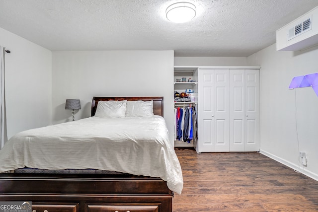1029 Megan Ct, Sugar Hill, GA 30518 - bedroom with dark wood finished floors, a closet, a textured ceiling, and baseboards