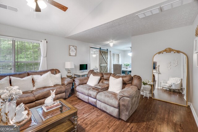 1029 Megan Ct, Sugar Hill, GA 30518 - living area with a barn door, wood finished floors, ceiling fan, vaulted ceiling, and baseboards