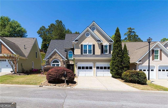 view of front facade with an attached garage, stucco siding, stone siding, and concrete driveway