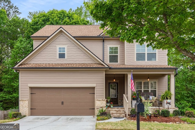 craftsman house featuring a garage, a porch, a shingled roof, and concrete driveway