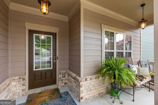 doorway to property featuring a porch and stone siding