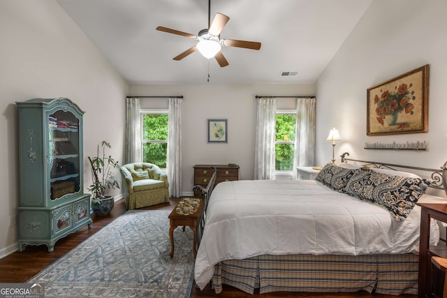 bedroom featuring wood finished floors, a ceiling fan, visible vents, baseboards, and lofted ceiling