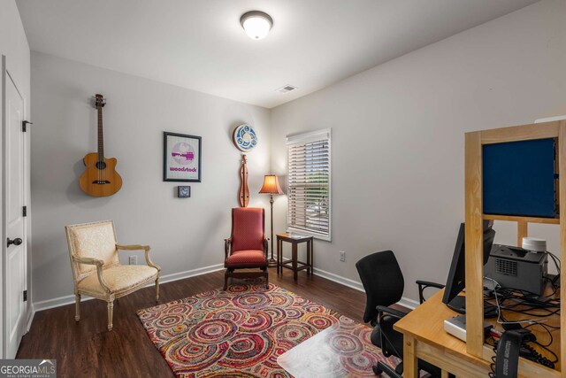 office space featuring wood finished floors, visible vents, and baseboards