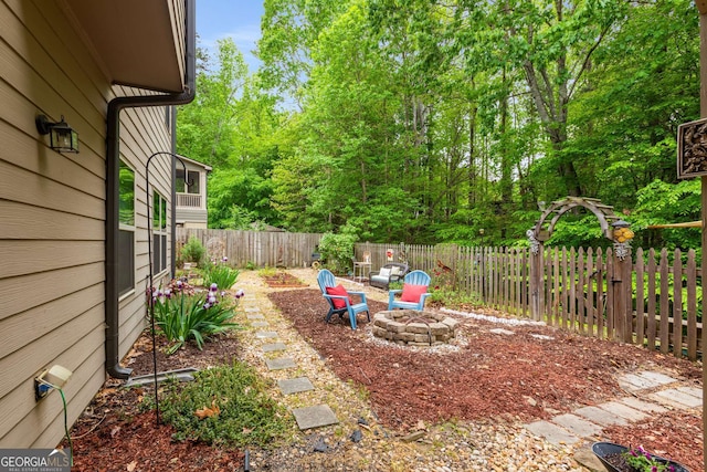 view of yard featuring a fire pit and a fenced backyard
