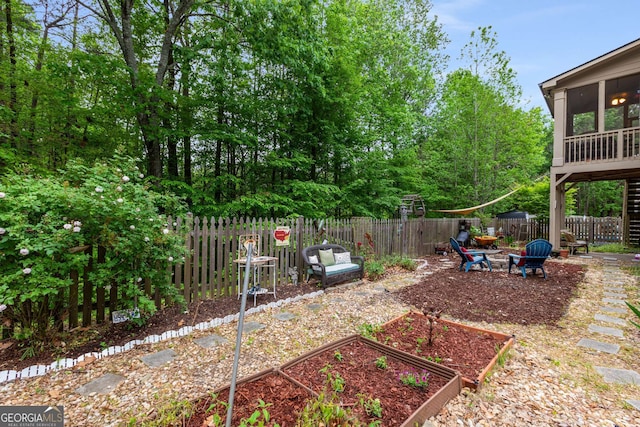 view of yard featuring a sunroom, a vegetable garden, and a fenced backyard