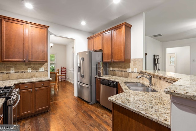 kitchen featuring light stone countertops, a sink, stainless steel appliances, visible vents, and dark wood finished floors