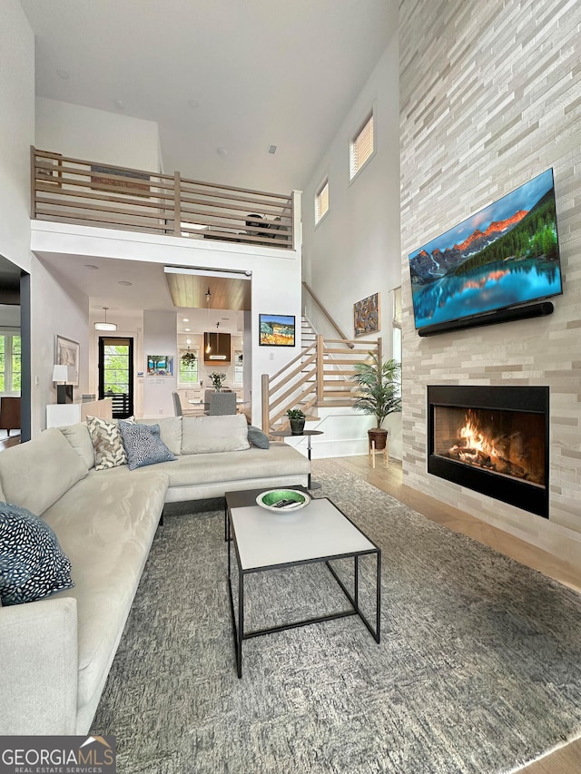 300 Mado Ln, Chattahoochee Hills, GA 30268 - living room featuring a high ceiling, stairway, wood finished floors, and a fireplace