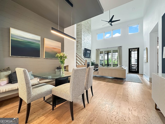 300 Mado Ln, Chattahoochee Hills, GA 30268 - dining area with hardwood / wood-style floors, ceiling fan, wooden walls, and a towering ceiling