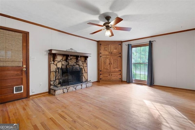 unfurnished living room with ceiling fan, ornamental molding, a fireplace, and light wood-style flooring