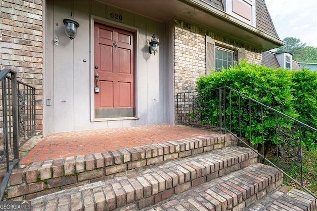 doorway to property featuring brick siding