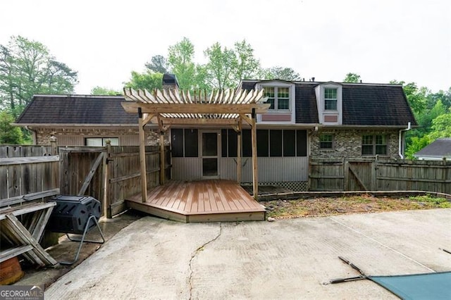 back of house with a pergola, a deck, a fenced backyard, and a gate