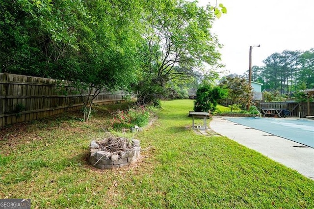 view of yard featuring fence, an outdoor fire pit, and a fenced in pool