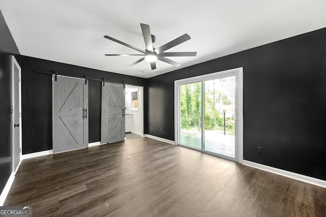2302 Aurie Dr, Decatur, GA 30034 - unfurnished bedroom featuring access to exterior, a barn door, dark wood-style floors, baseboards, and ceiling fan