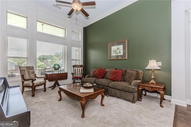 living room with ceiling fan, plenty of natural light, crown molding, and baseboards