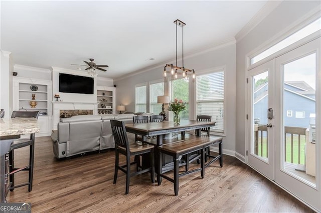 dining area with baseboards, ornamental molding, a ceiling fan, and dark wood-type flooring