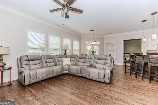 living room featuring crown molding, a ceiling fan, wood finished floors, and baseboards
