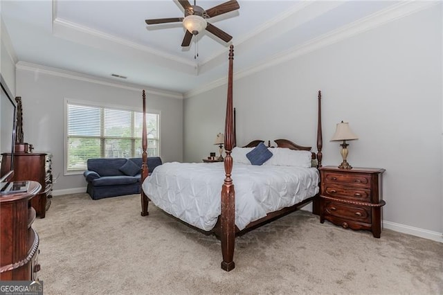 carpeted bedroom featuring crown molding, visible vents, ceiling fan, a tray ceiling, and baseboards