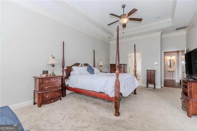 bedroom with baseboards, light carpet, crown molding, and a tray ceiling