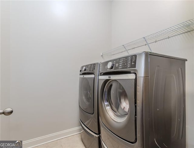 laundry room featuring baseboards, tile patterned flooring, laundry area, and independent washer and dryer