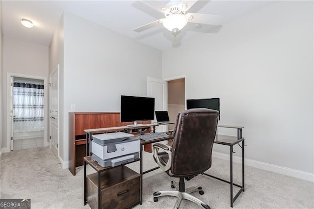 office area with baseboards, light carpet, and ceiling fan