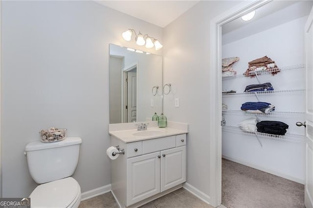 bathroom featuring vanity, toilet, and baseboards