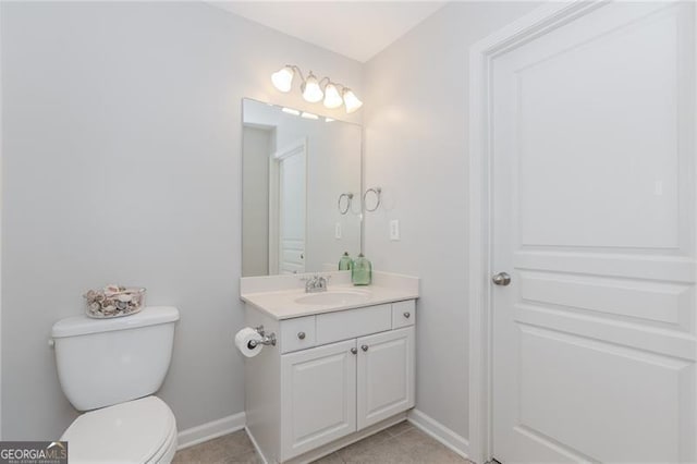 bathroom with vanity, toilet, tile patterned flooring, and baseboards