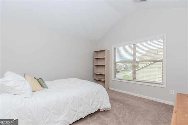 carpeted bedroom featuring baseboards and lofted ceiling