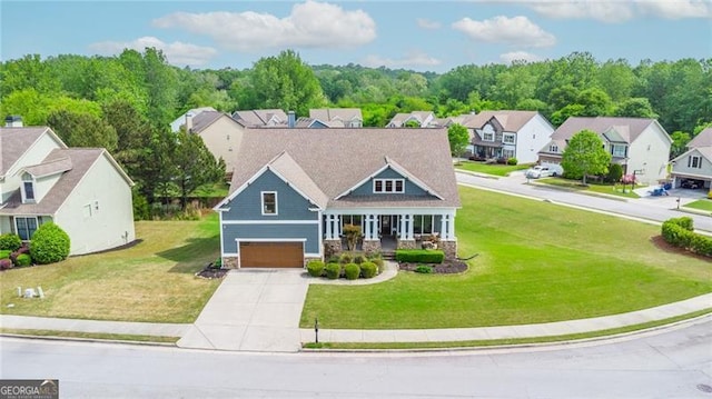 craftsman house with concrete driveway, a residential view, stone siding, a front yard, and a garage