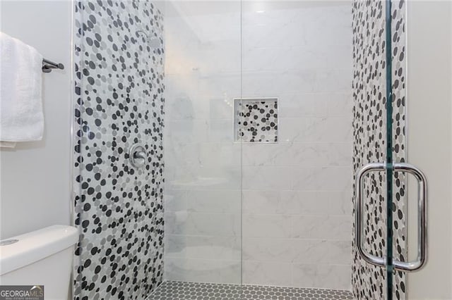bathroom with toilet and a stall shower
