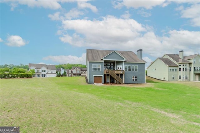 rear view of property featuring a residential view, a lawn, stairs, and a wooden deck